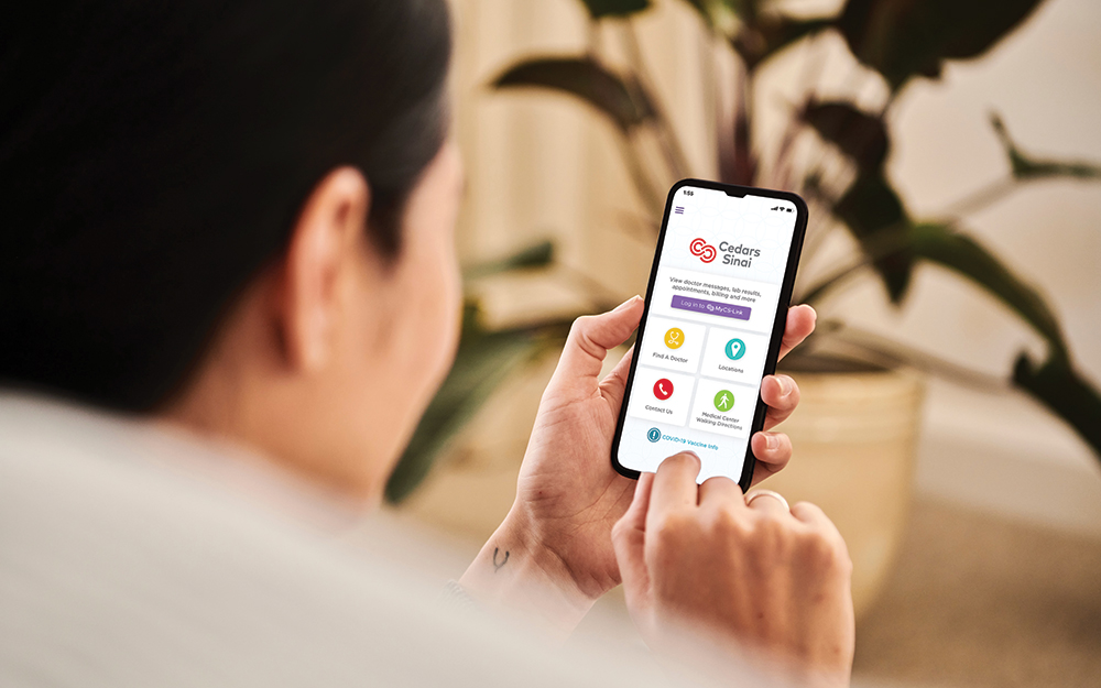 Person holding their phone with the Cedars-Sinai app oepn